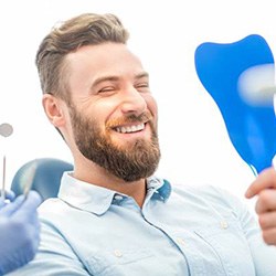 Man looking at smile in mirror