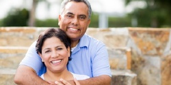 An older couple hugging outside.