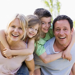 A family smiling outside.