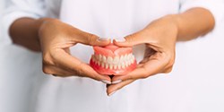 Lady presents viewer with dentures