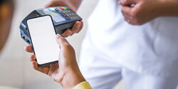 a patient using their phone to pay the cost of dentures