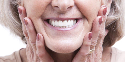 older woman smiling and wearing dentures in Denton 