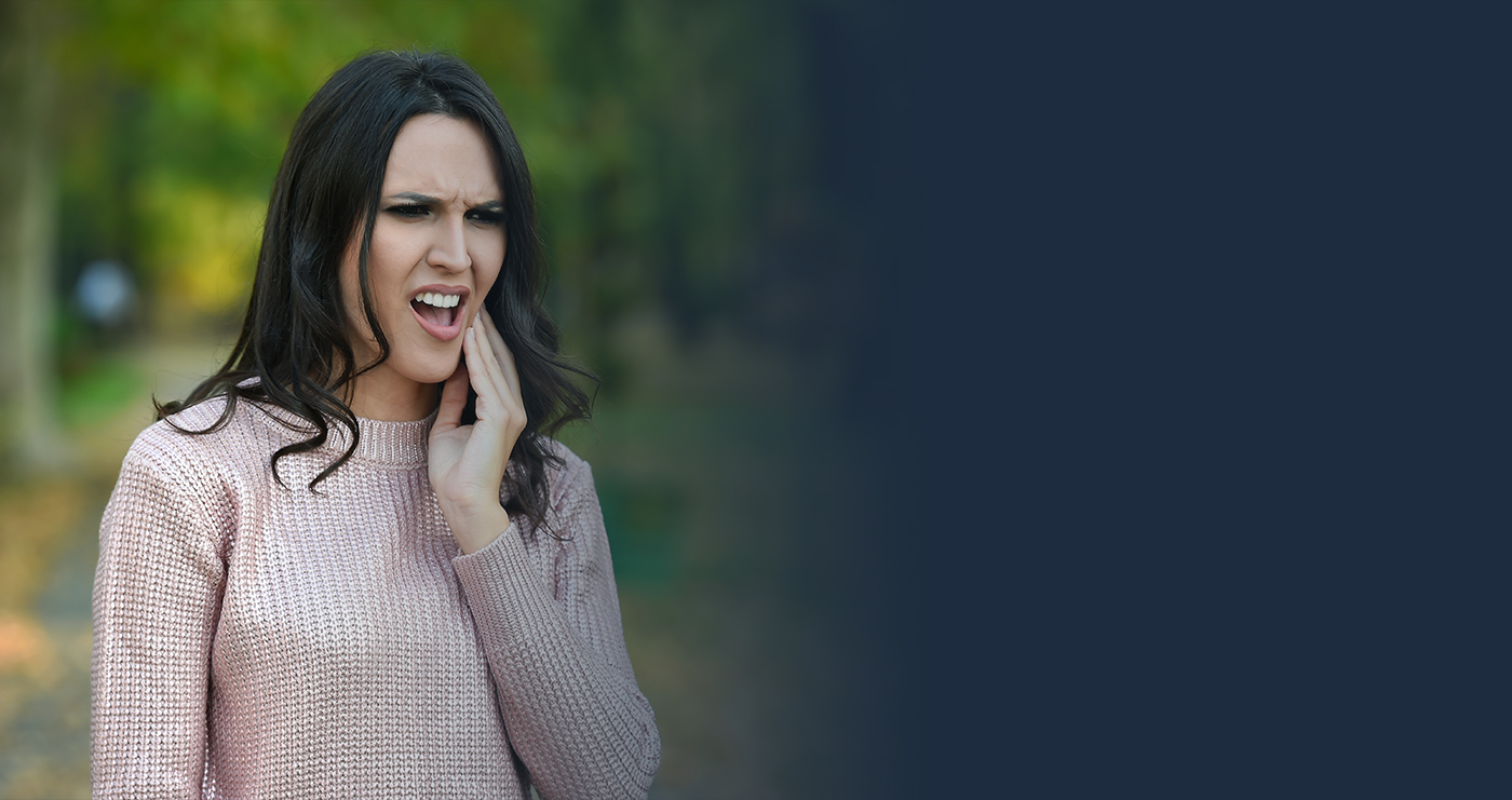 Woman in dental pain wearing pink sweater