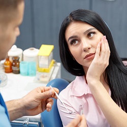 Woman holding jaw in pain