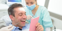 Man looking at smile in mirror