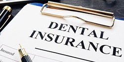 dental insurance form on a blue clipboard 