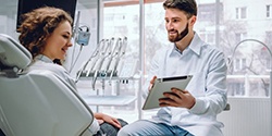 dentist showing a patient information on a tablet 