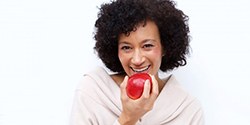 woman biting into a red apple 