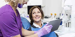 dentist showing a patient information on a tablet