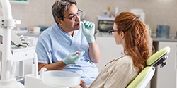 Dentist talking to woman in dental chair