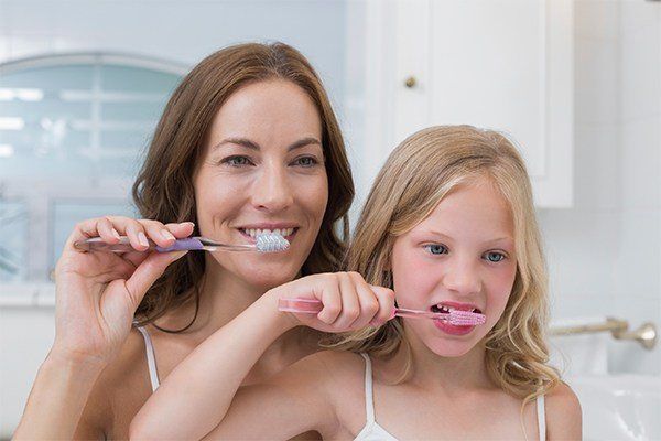 mother and daughter brushing teeth