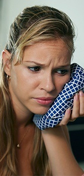 Woman using ice pack on face