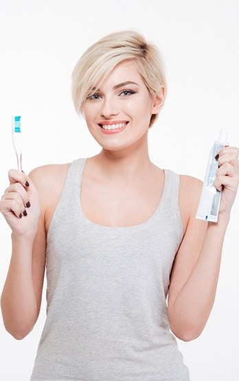 woman holding toothbrush and toothpaste