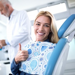 woman giving thumbs up dental chair before receiving nitrous oxide sedation in Denton