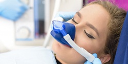 young woman wearing nitrous oxide mask over her nose 