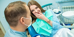 young woman smiling and talking to her dentist 
