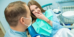 young woman smiling and talking to her dentist 