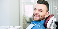 Man wearing denim shirt smiling in dental chair