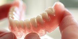 Person holding model denture