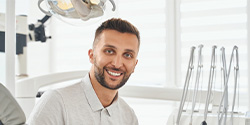 Man in dental chair smiling after tooth extraction in Denton, TX