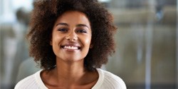 Woman in sweater smiling after teeth whitening in Denton, TX