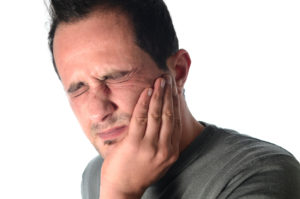 Man in pain holding cheek