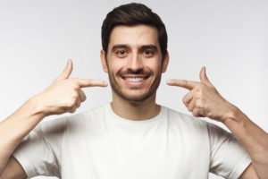 Clean smile in mirror after treatment with a Denton dentist.