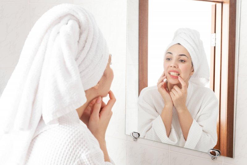 Woman looking at her teeth in the mirror