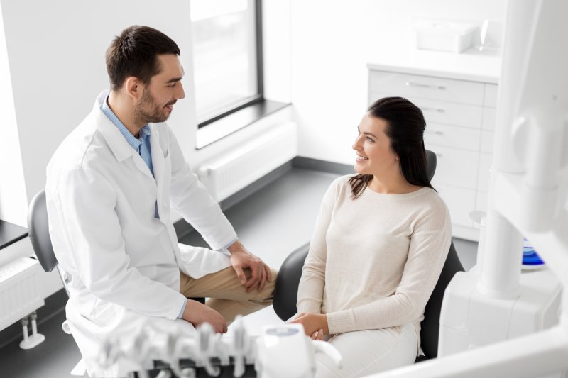 patient smiling while talking to dentist 