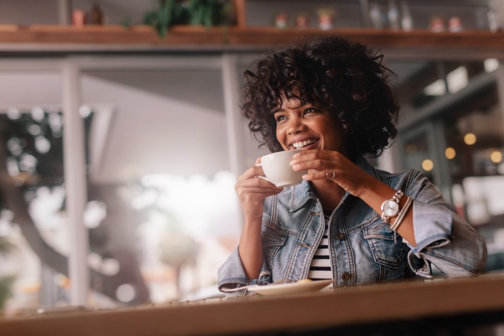 Woman smiling while drinking coffee
