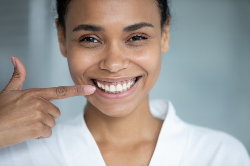 A woman pointing to her front teeth