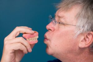 A man about to kiss dentures
