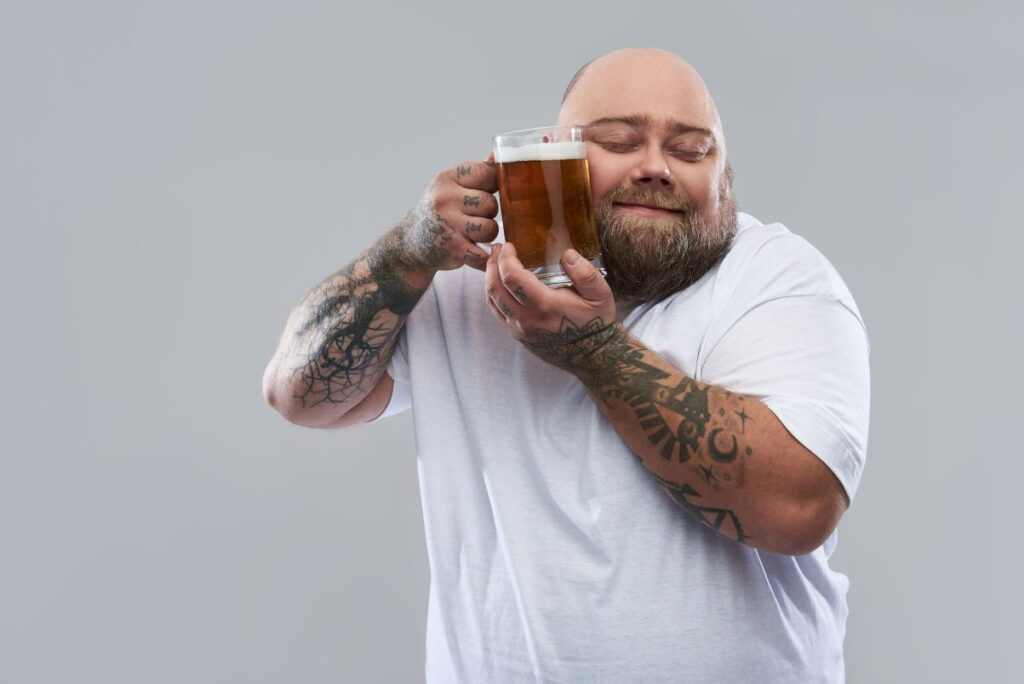 A man affectionately holding a glass of beer