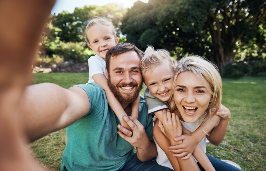 Family of four outside together taking selfie